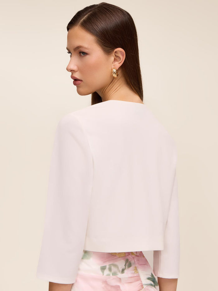 Knit crepe bolero with 3/4 sleeves and open-front design by Le Chateau.