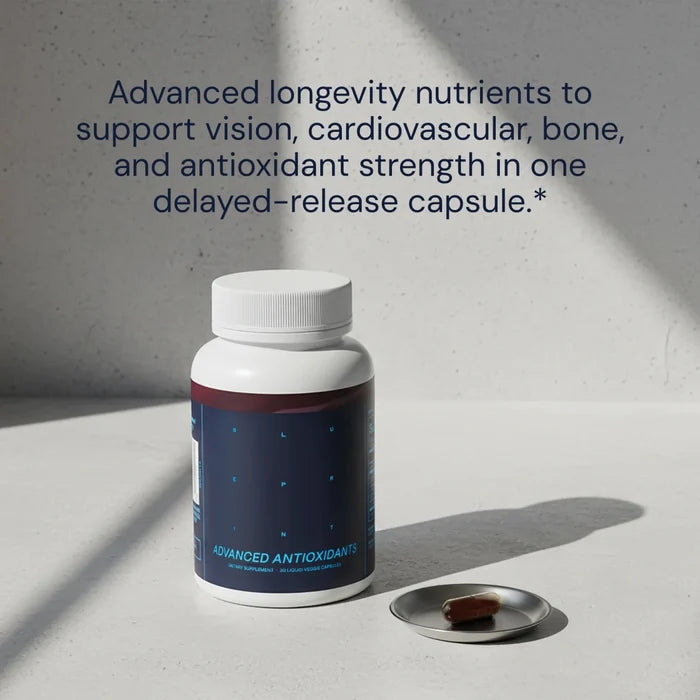 Bottle of 'Advanced Antioxidants' with a pill on a gray surface and text about nutrients.