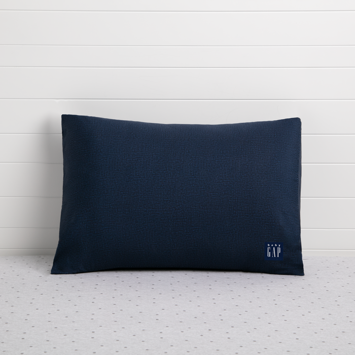 A navy-colored toddler pillow with a small logo on the bottom right corner, presented against a white background.