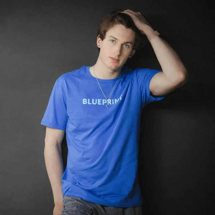 Person wearing blue Blueprint t-shirt on dark background