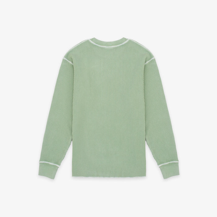 A sage green ribbed knit long-sleeve shirt with white contrast stitching on the shoulders, cuffs, and collar, shown flat against a light gray background.