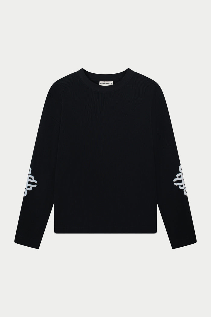 Black long sleeve t-shirt with white branding on sleeves against a light grey background