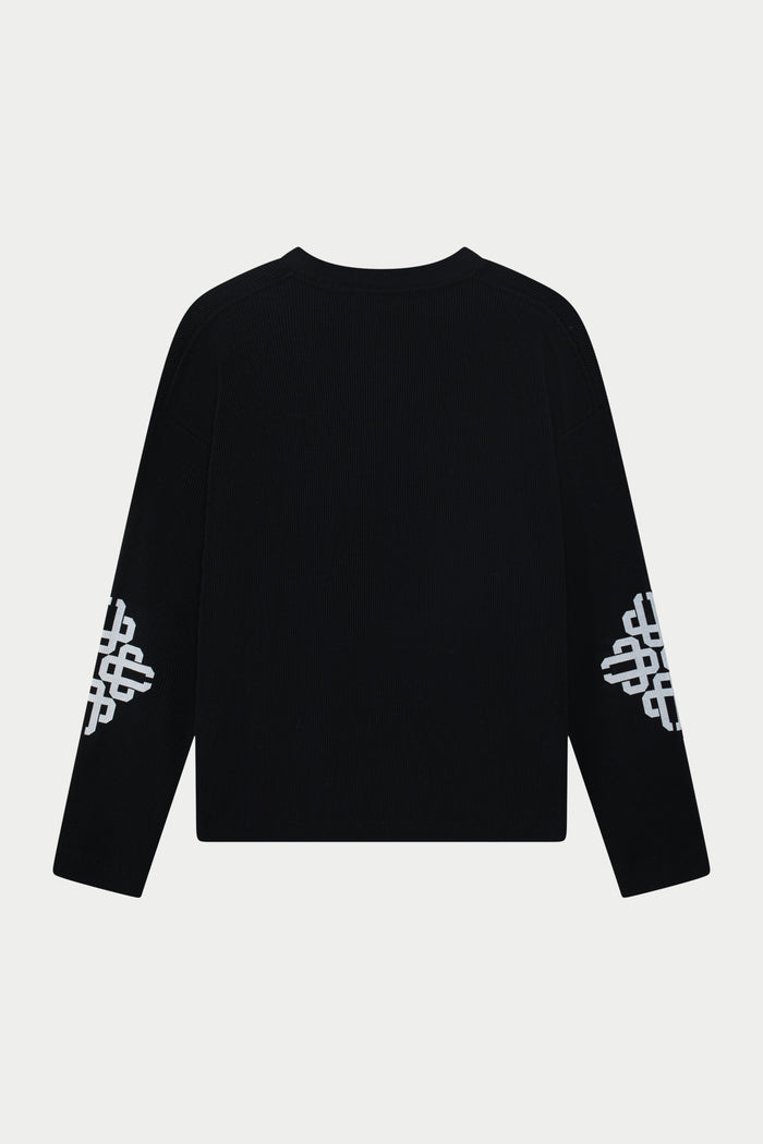 Black long sleeve t-shirt with white patterns on sleeves against a light grey background
