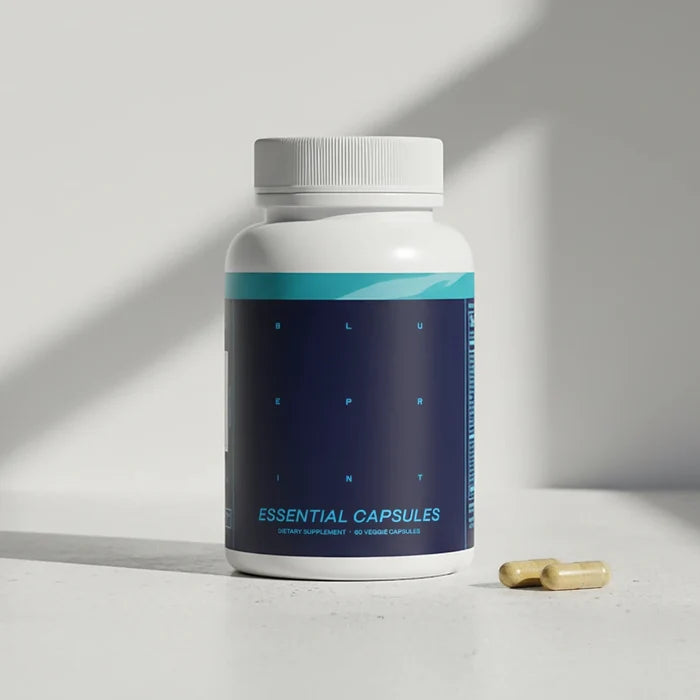 Supplement bottle labeled 'Essential Capsules' with a pill on a light surface