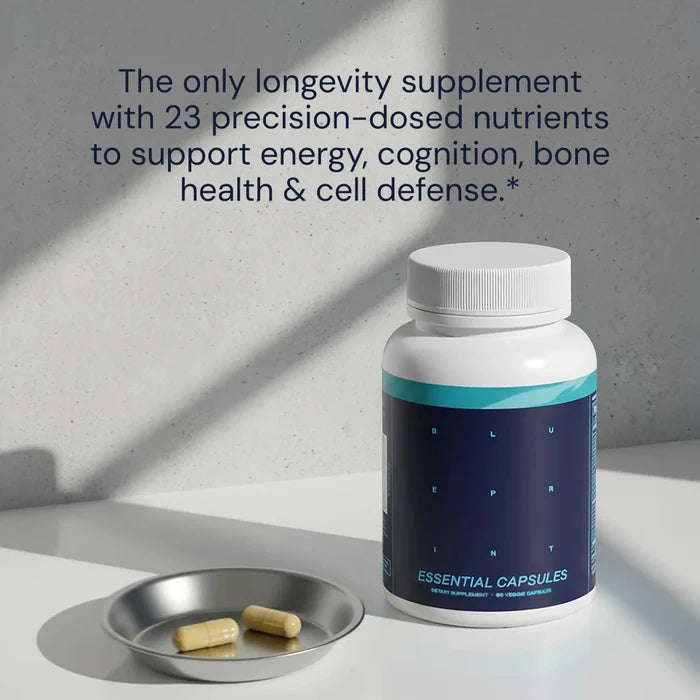 Supplement bottle labeled 'Essential Capsules' with two capsules on a tray against a gray background.