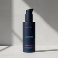 Blue bottle of Blueprint Cleanser on a light gray background