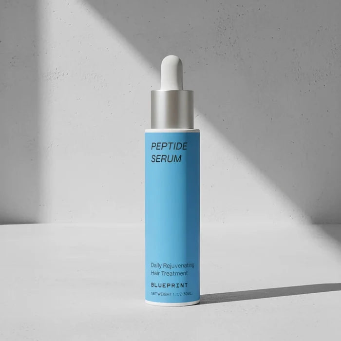 Blue peptide serum bottle with dropper on a gray background