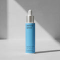 Blue peptide serum bottle with dropper on a gray background