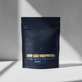 Dark blue package of raw macadamias on a light gray background