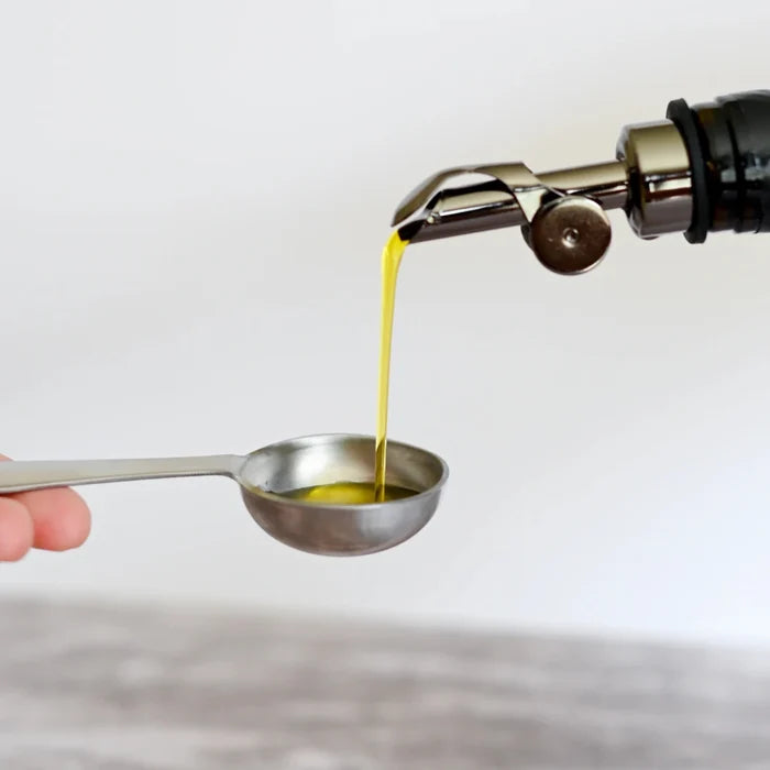 Blueprint Bryan Johnson Extra Virgin Olive Oil pouring into bowl with fresh ingredients