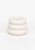 A taper candle holder with 3-layer stacked donut shape in white.